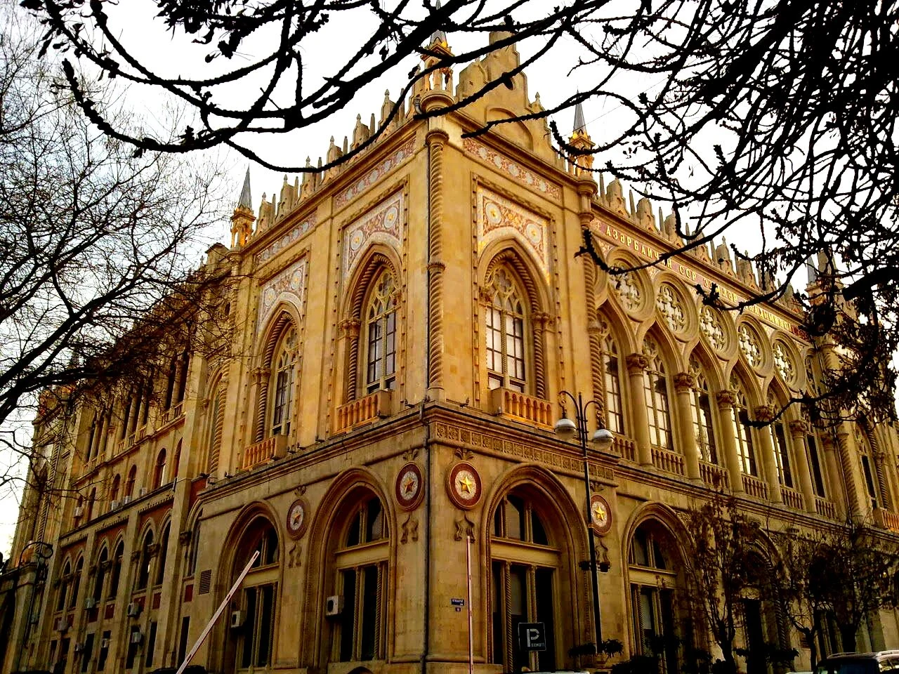 Golden stone arches and ornate Gothic-style façade of Ismailiyya Palace in Baku, Azerbaijan